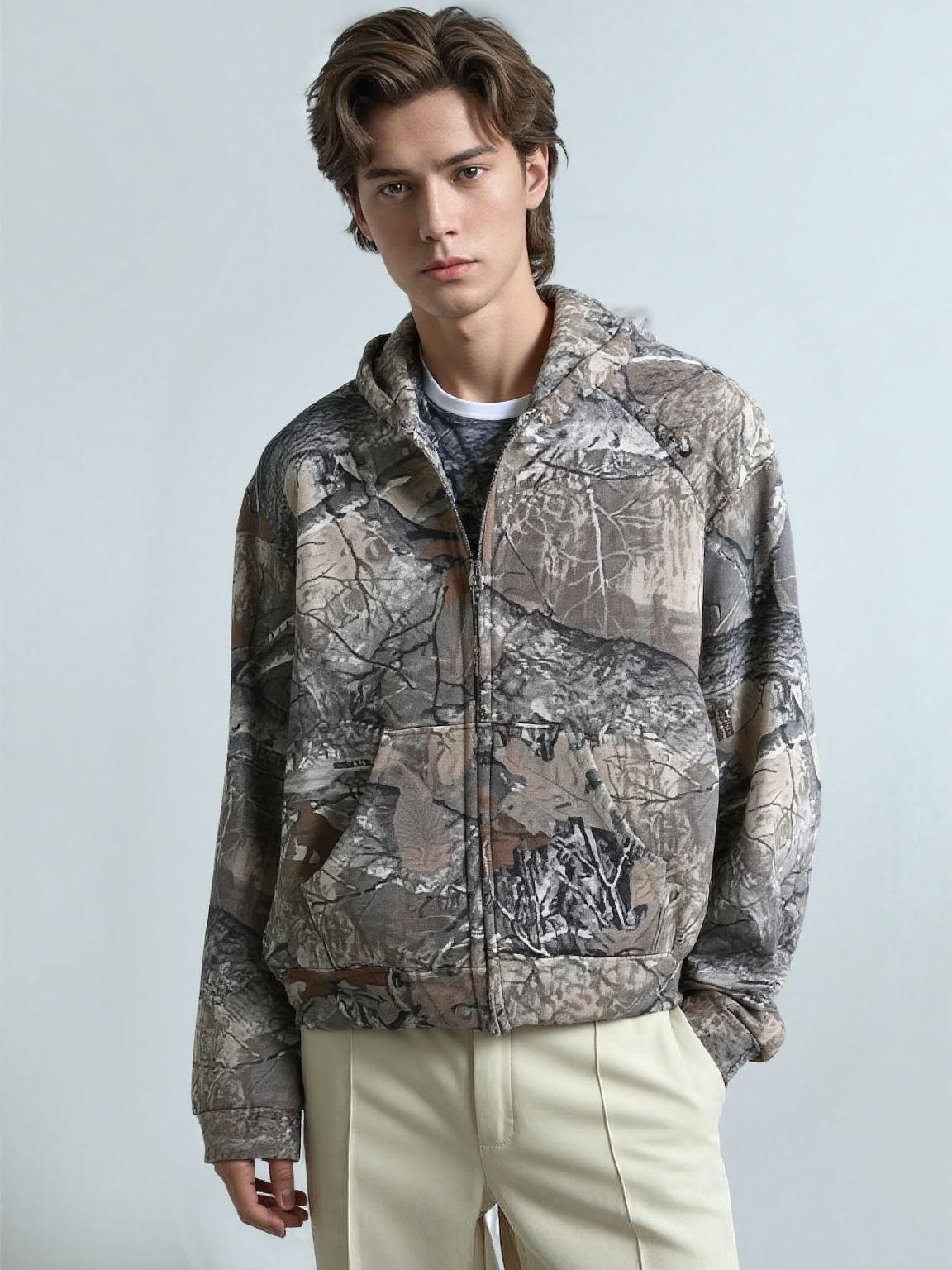 A guy wearing the camouflage hoodie with a zipper
